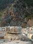 Frieze Of Stone Masks From Ancient Theatre With Rock-Cut Tombs In Background, Myra by Natalie Tepper Limited Edition Print