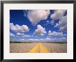 Cumulus Clouds In Blue Summer Sky Over Paved Road by John Eastcott & Yva Momatiuk Limited Edition Print