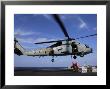 Two Aviation Ordnancemen Connect Transport Cables To A Sh-60B Helicopter by Stocktrek Images Limited Edition Print