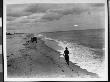 A Woman In A Bathing Outfit Running Towards A Group Of Four People By The Shore At Belmar, Nj by Wallace G. Levison Limited Edition Print