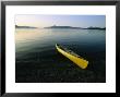 Yellow Canoe On The Shore Of A Calm Body Of Water by Michael Melford Limited Edition Pricing Art Print