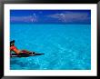 Woman Basking In The Sun On An Outrigger Boat In An Island Lagoon, Huahine Iti, French Polynesia by Jean-Bernard Carillet Limited Edition Print