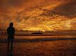 Silhouetted Person Enjoying Sunset On A Deserted Beach by Tim Laman Limited Edition Print