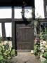 Doors - Half-Timbered Cottage- Wooden Door And Iron Hinges, Approached By Flagstone, Hollyhocks by David Mark Soulsby Limited Edition Pricing Art Print