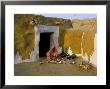 Woman Cooking Outside House With Painted Walls, Village Near Jaisalmer, Rajasthan State, India by Bruno Morandi Limited Edition Print