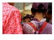 Young Child With Thanaka Painted On Face Peering Between Shoulders, Kalaw, Myanmar (Burma) by Anthony Plummer Limited Edition Pricing Art Print