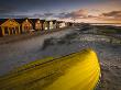 Beach Front Huts And Upturned Punt At Mudeford, Dorset, England by Adam Burton Limited Edition Print