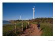 A Man Walks Along A Path Near Wind Turbines by Taylor S. Kennedy Limited Edition Pricing Art Print