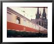 Eurailpass In Europe: Germany's Parsifal Express Speeding Past Cologne Cathedral by Carlo Bavagnoli Limited Edition Print