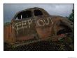 Remains Of An Old Car With A Keep Out Sign Painted On Its Side by Annie Griffiths Belt Limited Edition Print